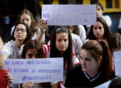 Estudiantes con carteles en los que se lee 