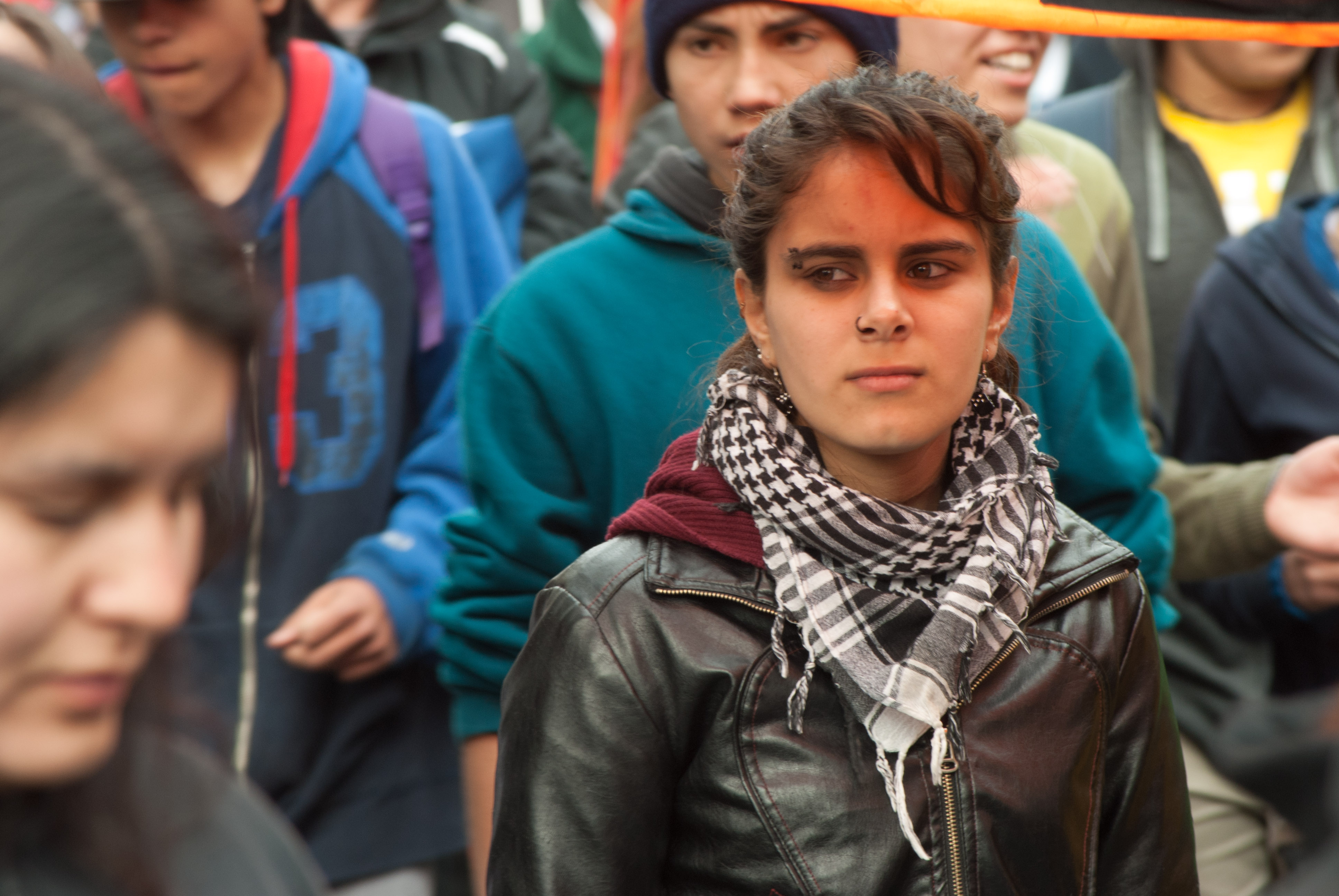 Estudiante en protesta, con una chaqueta de cuero y una bufanda